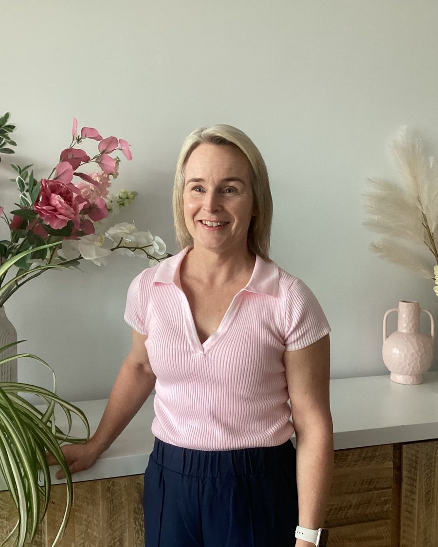 Linda Kenny, founder of Adelaide Massage Connection, smiling in a light-filled room